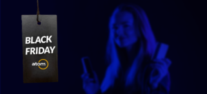 Black Friday 2022 - moça com o celular na mão aproveitando as promoções - Atom Educacional